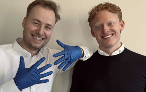 Een foto van Thijs Groenen (links) en Matz van Neusel (rechts). Thijs draagt de blauwe Gloovy Eco Gloves en laat deze op de foto zien. 