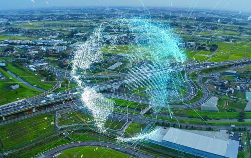 Digitale wereldbol zwevend boven een luchtbeeld van een snelweg/stad